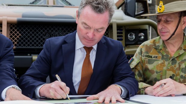 Minister for Defence Industry Christopher Pyne signs the acceptance of the last two Hawkei Pilot vehicles at a ceremony at Victoria Barracks last year.