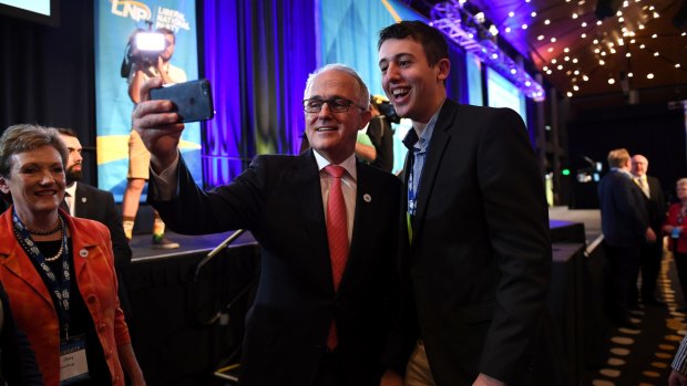 Prime Minister Malcolm Turnbull takes a selfie with a young party member at the LNP state conference in Brisbane on Saturday