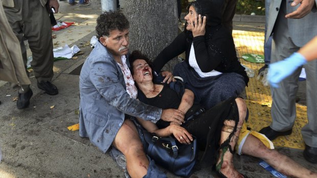 Wounded people wait for help at the site of the blast on Saturday.