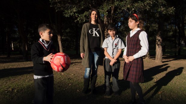 Georgi York with her children Phoenix, 6, Zac, 8, and Ellie, 10, at a park across the road from Anzac Park Public School.