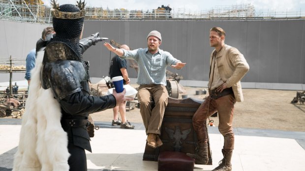 (From left) Jude Law as Vortigern, director Guy Ritchie and Charlie Hunnam on the set of <i>King Arthur</i>. 