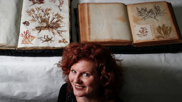 Julie Ryder with the two rare seaweed albums that will go on display at the National Museum of Australia in April.