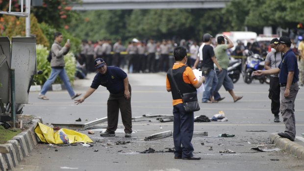 Police officers examine debris at the explosion site. 