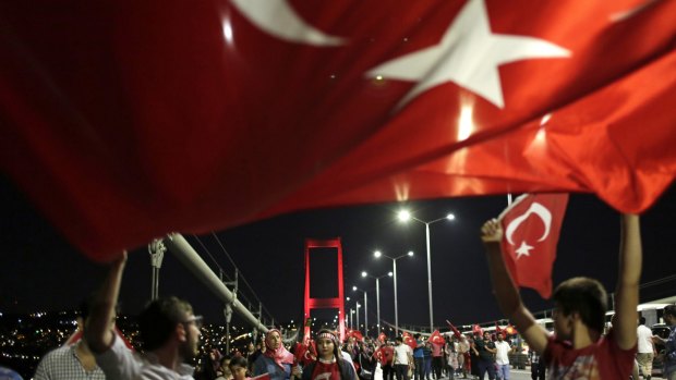 Pro-government supporters wave a Turkish flag as they protest on Istanbul's Bosporus Bridge on Thursday.