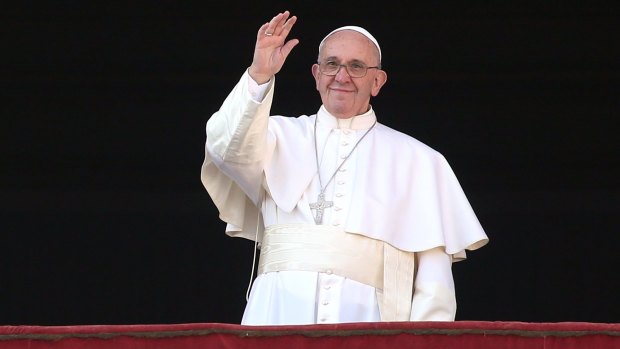 Pope Francis waves to the faithful as he delivers his 'Urbi et Orbi' blessing.