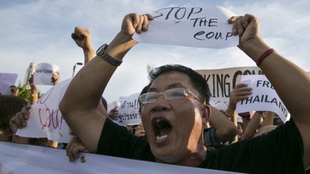 Protesters holds signs during an anti-coup protest on the second day of Thailand's military coup on May 24, 2014, in Bangkok.