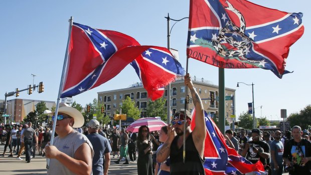 A group carries confederate flags past a Black Lives Matter rally in Oklahoma City, Oklahoma, on Sunday.