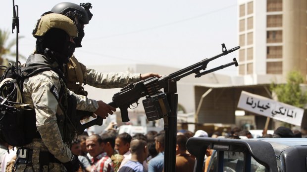 Iraqi policemen stand guard during a rally in support of Iraqi Prime Minister Nouri al-Maliki in Baghdad on Monday.