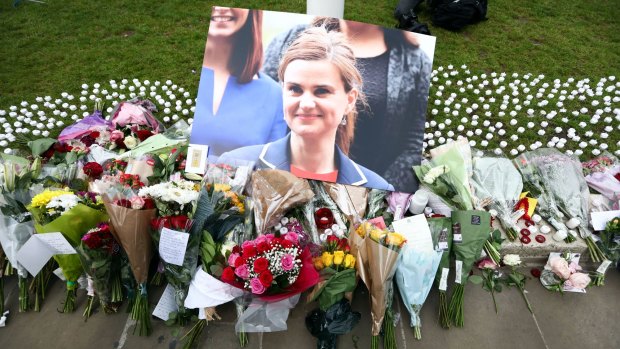 Flowers surround a photograph of British MP Jo Cox. Her death is almost forgotten in the social media storm about how to characterise her attacker.