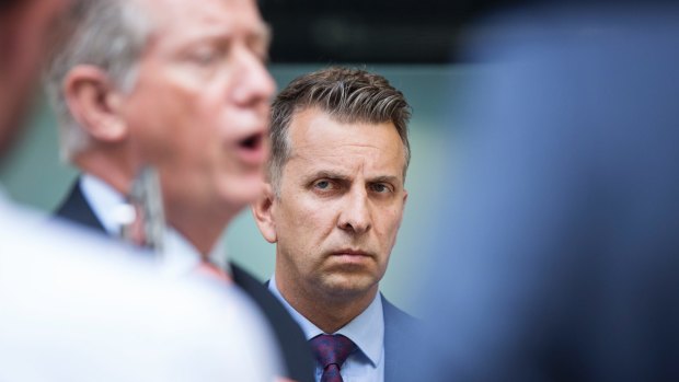 NSW Minister for Transport and Infrastructure Andrew Constance looks at Sydney Trains chief executive Howard Collins as he answers questions during a joint press conference on Tuesday's delays.