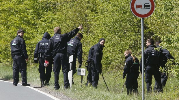 German police officers search for evidence in a forest near Oberursel. German police have recovered a pipe bomb, an assault rifle and chemicals that can be used to make explosives after two suspects were detained in an overnight anti-terror raid near Frankfurt.