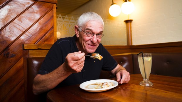"The Original Pancake Man" Philip Barton eating pancakes that he made, topped with whipped butter and maple syrup.