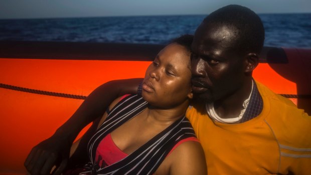 A woman and a man from Niger rest aboard a rescue boat after they fell into the water from the rubber boat in the Mediterranean in September. 