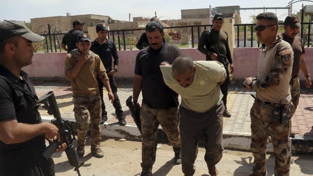 Iraqi security forces arrest a suspected fighter with Islamic State, west of Baghdad on Wednesday. 
