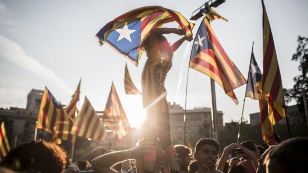 Demonstrators wave Catalan flags while marching through the city to protest against alleged police violence during Sunday's illegal referendum vote in Barcelona.