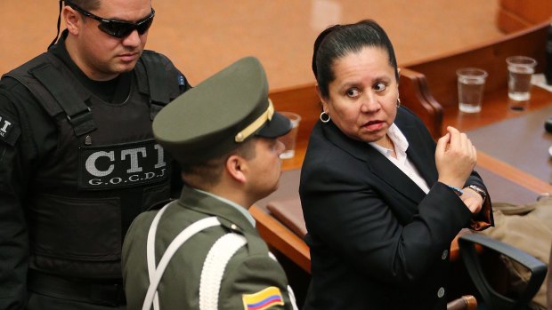 Maria del Pilar Hurtado (right), former head of Colombia's domestic intelligence agency, is escorted by judicial police into the Colombian Supreme Court to receive her sentence.