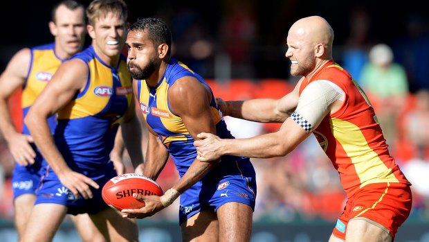 Lewis Jetta is pressured by the defence of Gary Ablett at Metricon Stadium.