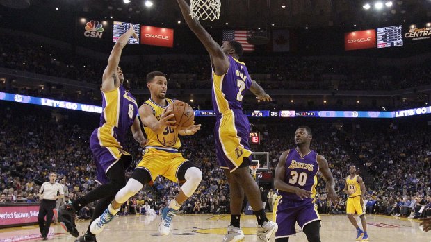 Mid-air magician: Golden State Warriors guard Stephen Curry looks to pass against the Los Angeles Lakers.