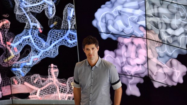 Dr Berry standing in front of images detailing the structure of the CMV protein. 