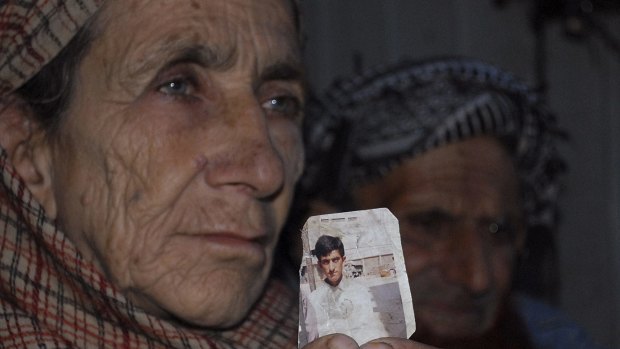Shafqat Hussain's mother Makhni Begum holds a photograph of her son.