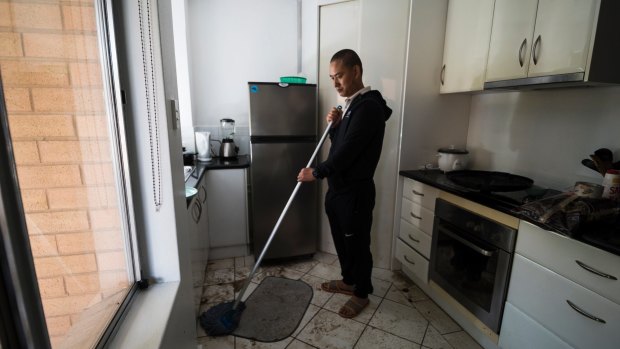 Sangay Yeser cleaning his apartment after flooding in O'Connor. 