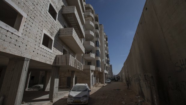A building under construction next to Israel's separation wall in the Kufr Aqab neighbourhood of Jerusalem. Planned demolitions threaten to drive people out of their homes.  