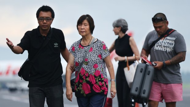 Australian Consulate staff assist Helen Chan, the mother of Bali Nine member Andrew Chan, followed by his brother Michael Chan as they arrive at Yogyakarta airport.