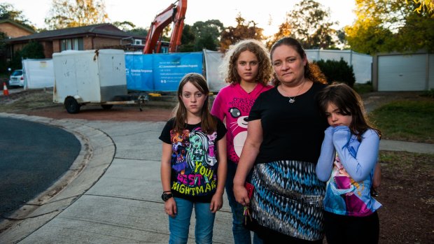 Eden O'Mara with  daughters Kimberley, 10, Jennifer, 12, and Rachael, 7, outside their Mr Fluffy house in Kambah that was demolished on Thursday. She is devastated by the discovery of a cabinet she believes is hers in a shipping container.