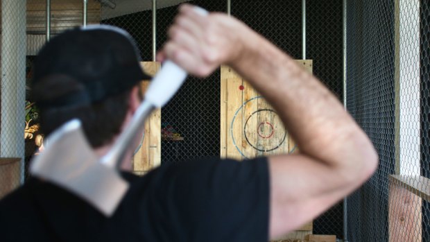 Adam Schilling, co-owner of Maniax, gets ready to throw an axe at one of the targets.