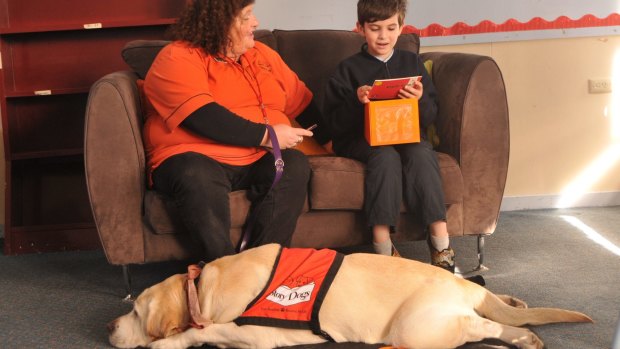 Classroom canine: Story Dogs program volunteer Teena Hartnett and Atticus help Glengala Primary School student Yacob with his reading.