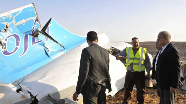 Egyptian Prime Minister Sherif Ismail, right, looks at the remains of the jet.