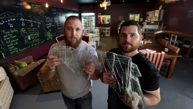 Co-owners of Eat me Drink me at the Kaleen shops and
former army buddies, Jay Logan and John Wellfare hold up glass shards from the break in.
