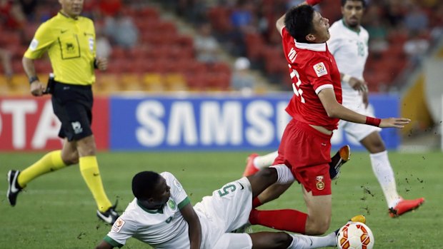 Ouch: Saudi Arabia's Omar Hawsawi tackles China's Yu Hai. 