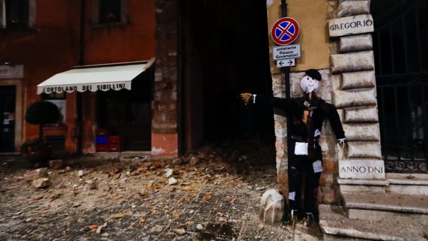A Halloween dummy rests on a wall in the town of Visso in central Italy early on Thursday.