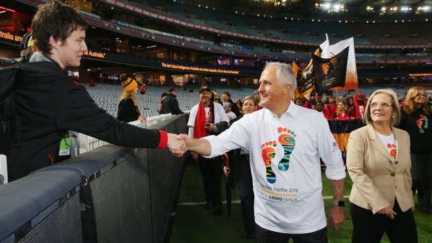 Malcolm Turnbull, with wife Lucy, shakes a Bombers fan's hand during The Long Walk before the round 10 AFL match.