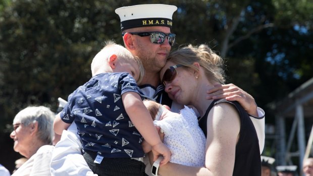 The families of crew of HMAS Darwin hug their loved ones before they depart from Garden Island on Wednesday.