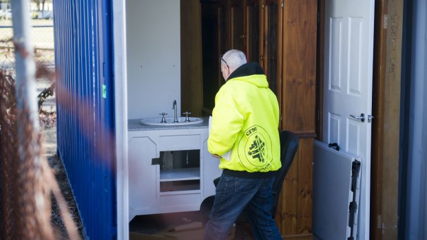 CFMEU legal officer Garry Hamilton inspects a shipping container, containing a wall cabinet, in a Fluffy contractor's yard.