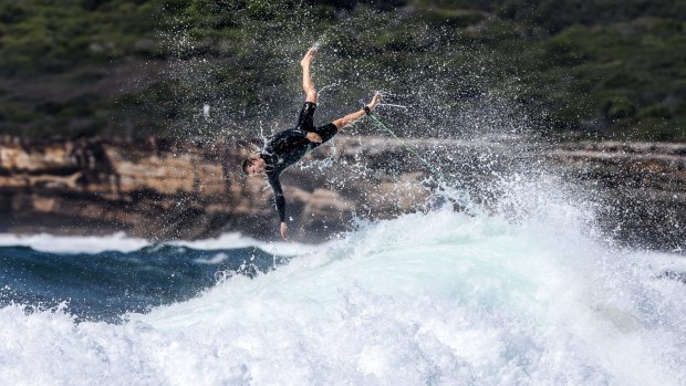 A surfer flies off the back of a large wave at Maroubra. 
