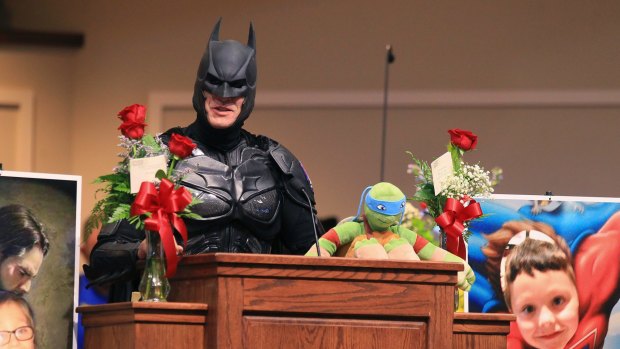 John Buckland, dressed as Batman, speaks during a superhero-themed funeral service for Jacob Hall in Townville, South Carolina, on Wednesday.