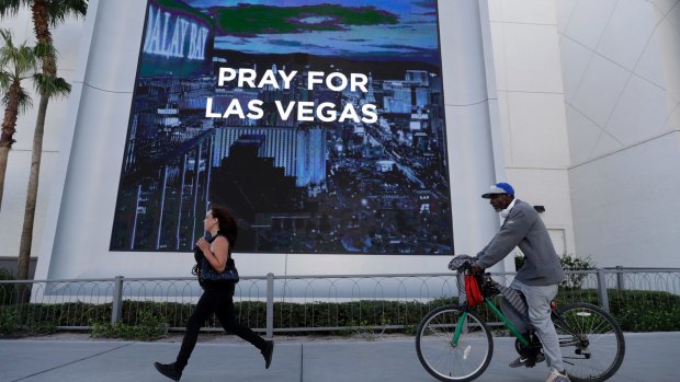 People travel past a sign honoring the victims of a mass shooting in Las Vegas.