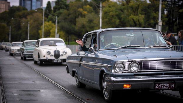 Classic cars take veterans at the start of the Anzac Day march in Melbourne. 