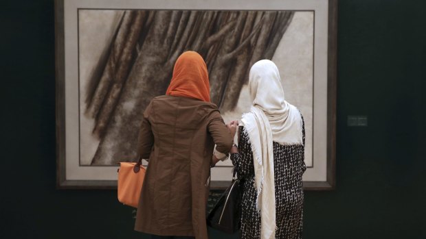 Iranian women in the required Islamic garments at an art auction in Tehran on Thursday. 