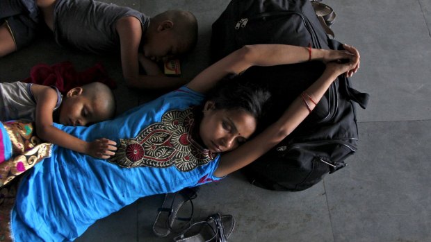 A passenger and her children sleep at a railway station in Allahabad, where temperatures reached 46.4 degrees this week.