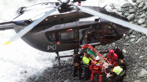 Rescue workers load an injured man on a stretcher after he was retrieved from the bus wreckage.