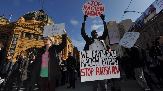 Demonstrators protesting against planned border protection raids stop traffic outside Flinders Street Station on Friday.