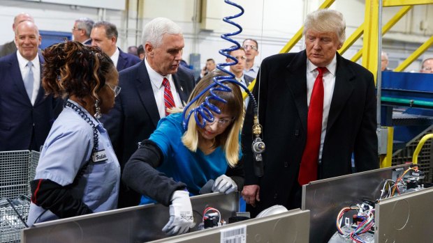 President-elect Donald Trump and vice-president-elect Mike Pence watch as employees work during a visit to the Carrier factory in Indianapolis.