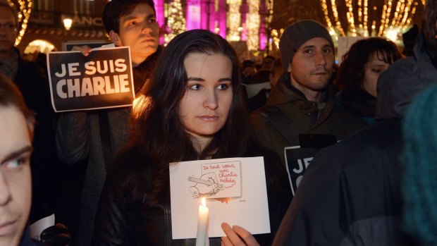 People hold placards reading in French "I am Charlie" (left) and "With all our heart with <i>Charlie Hebdo</i>" during a gathering in Strasbourg, eastern France, following the  attack by unknown gunmen on the offices of the satirical weekly. 