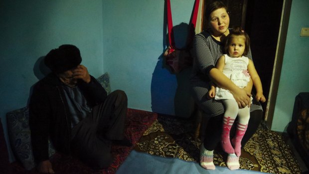 Elnara, the wife of arrested Tatar protester Ali Asanov, sits with one of her daughters, Mumine, in her home in the village Urozhayne, Crimea. 