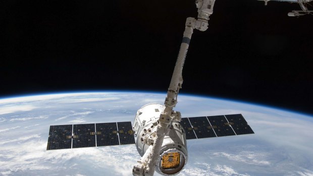 The SpaceX Dragon commercial cargo craft is grappled by a robotic arm at the International Space Station.