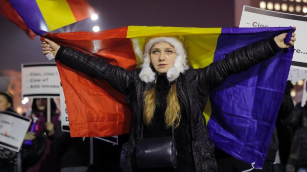 A girl waves a Romanian flag during the protest against the new law in Bucharest on Thursday.